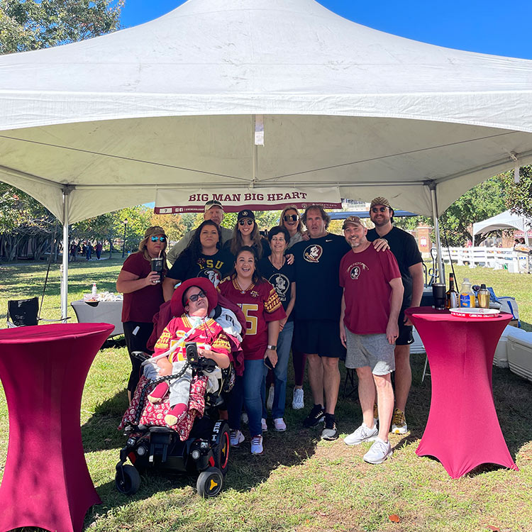 The Gibbons family posing under the Big Man Big Heart tent with family and friends