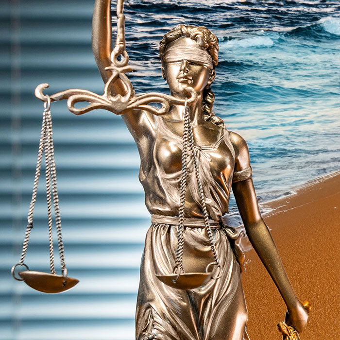 Lady Justice in front of a beach background