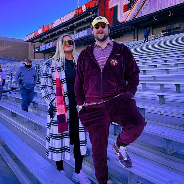 Reilly Gibbons posing with his sister Delanie Gibbons on the bleachers at a football stadium