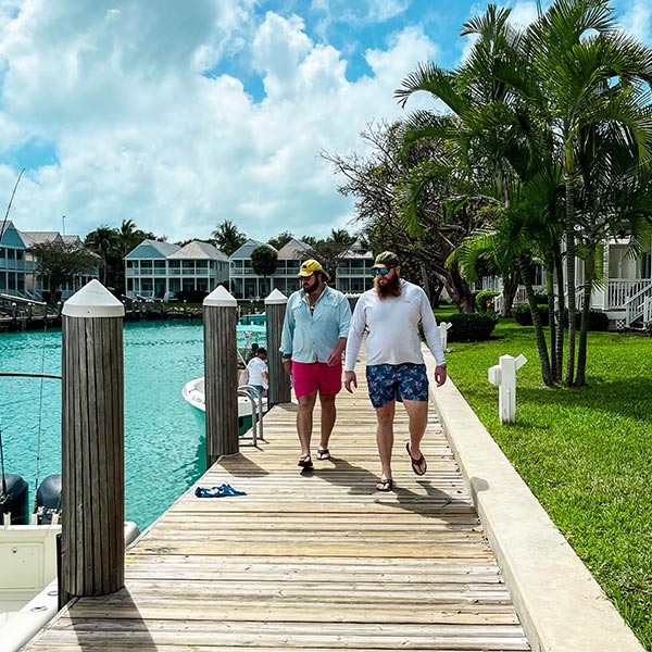 Reilly Gibbons and Dylan Gibbons walking on a dock next to ocean water